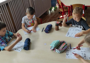 Dzieci z grupy Misie uzupełniają kartę pracy dotyczącą numerów alarmowych.
