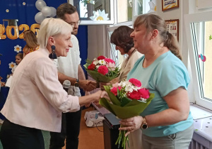 Zdjęcie przedstawia rodziców wręczających kwiaty pani dyrektor i pani wicedyrektor.