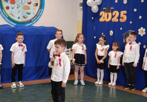 Zdjęcie przedstawia dziecko recytujące wiersz.