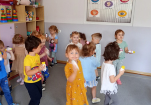 Przedszkolaki prezentują i grają na samodzielni wykonanych grzechotkach.