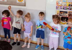 Kilkoro dzieci stoi z instrumentami trzymanymi w dłoniach.