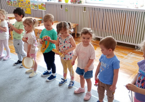 Przedszkolaki trzymające instrumenty muzyczne.