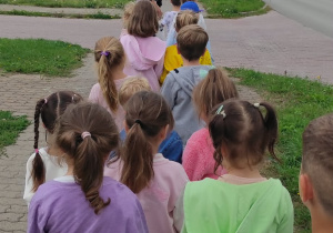 Dzieci idące parami po chodniku.