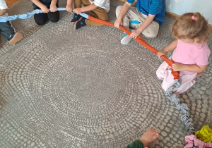 Dzieci wspólnie bawią się gumą sensoryczną.