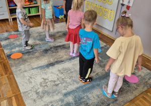 Zdjęcie przedstawia matę do kodowanie na której rozłożone są kolorowe kropki i robota Zosie poruszającego się po polach maty w poszukiwaniu właściwej drogi do kropki