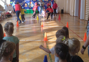 Dzieci przemierzają sportowy tor przeszkód.