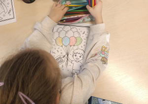 Dziewczynka z grupy „Motylki” przygotowuje laurkę dla swojego kolegi z okazji Dnia Chłopaka.