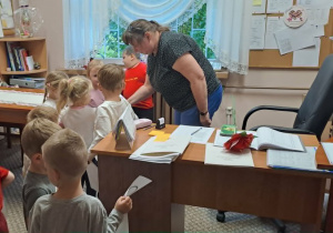 Pani Wicedyrektor częstuje dzieci cukierkami.