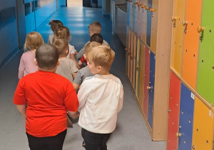Dzieci idą parami korytarzem przedszkolnym.