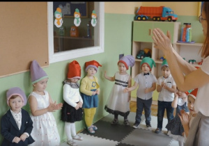 Dzieci i nauczycielka z grupy krasnale klaszczą w ręce.