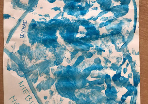 Na białym kartonie namalowany niebieską farbą kontur serca, wypełniony odbitymi na niebiesko dłońmi dzieci oraz podpisami kolejnych dzieci z grupy. Po prawej i lewej na dole serca napis: „Jesteśmy z Wami Niebieskimi Motylami”.