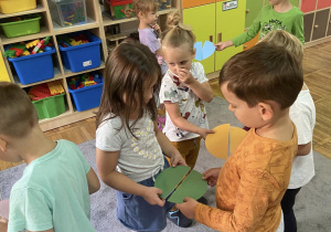 Na zdjęciu znajduje się grupa dzieci, które łączą się w pary, tworząc kropkę z dwóch połówek.