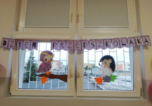 Napis Dzień Przedszkolaka powieszony wzdłuż okien.
