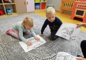 Dwójka dzieci układa obrazek przedstawiający dziewczynkę.