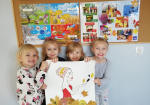 Dziewczynki trzymają ilustrację wcześniej wykonywanej Pani Jesień.