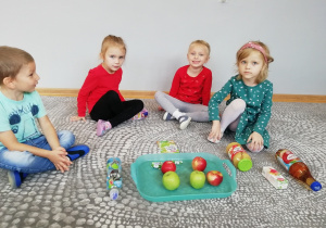 Dzieci oglądają jabłkowe produkty.
