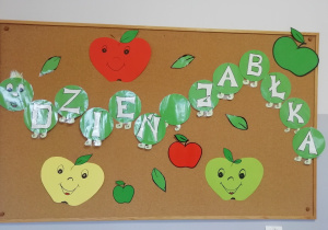 Dekoracja na tablicy przedstawiająca kolorowe jabłuszka.