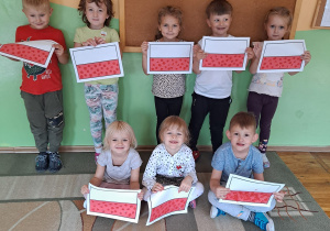Dzieci z grupy Misie pozują do zdjęcia trzymając w rękach samodzielnie wykonane flagi Polski