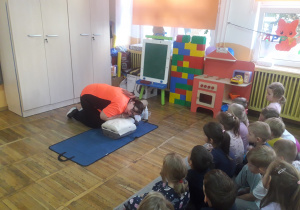 Pani Ewelina pokazuje jak sprawdzać czy osoba poszkodowana oddycha na fantomie.