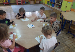 Dzieci malują farbami makaron.