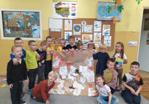 Dzieci pokazują samodzielnie wykonany plakat z okazji Dnia Postaci Z Bajek.