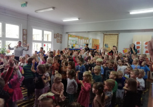 Dzieci wraz z Panią Wicedyrektor oraz Paniami Nauczycielkami tańczą do piosenki podnosząc ręce do góry.