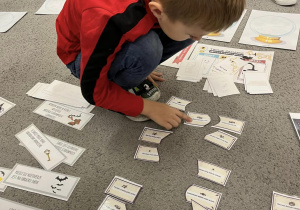Chłopiec łączy w pary karteczki z magicznymi zaklęciami.