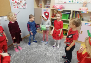 Dzieci stoją w kole i podają sobie prezent.