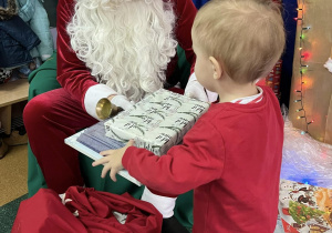 Chłopiec odbiera prezent od Mikołaja.