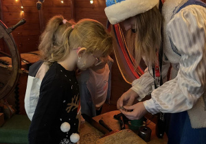 Dziewczynka wybija własna monetę w Mennicy Świętego Mikołaja.