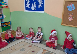 Dziewczynki i chłopcy nieco onieśmieleni patrzą na wyjątkowego gościa- Świętego Mikołaja.
