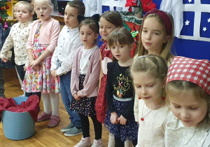 Zdjęcie przedstawia dzieci śpiewające piosenkę świąteczną.