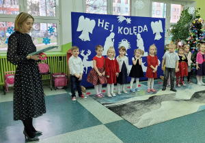 Nauczycielka z dziećmi wita przybyłych gości
