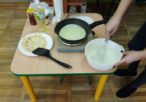 Nauczycielka piecze naleśniki.
