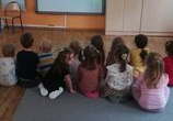 Dzieci odwrócone są do tablicy multimedialnej i oglądają film na temat bezpieczeństwa w sieci.