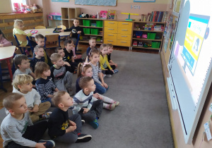 Dzieci z grupy Pszczółki oglądają film "Szanuj innych w sieci" na tablicy interaktywnej.