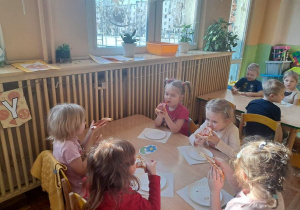 Dzieci z grupy Misie z okazji Dnia Pizzy zajadają pizzę.
