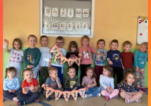 Zdjęcie grupowe dzieci, które trzymają napis „Dzień pizzy”.