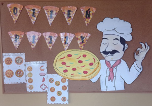 Zdjęcie przedstawia napis :” Dzień pizzy” obok, którego przypięta jest ilustracja kucharza trzymającego pizze. Na tablicy przypięte są również karty pracy z zagadkami dotyczącymi pizzy.