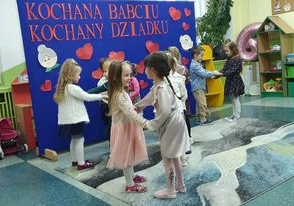 Dzieci trzymają się za ręce i tańczą do piosenki Dwóm tańczyć się zachciało.