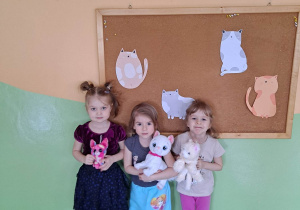 Na tym zdjęciu dziewczynki trzymają swoje maskotki- koty.