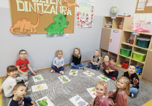 Przedszkolaki siedzą w kole a przed każdym z nich leżą ułożone puzzle.