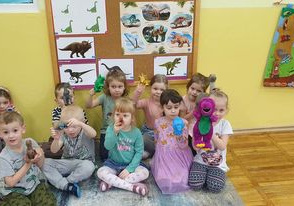 Dzieci pozują do zdjęcia ze swoimi dinozaurami, które przyniosły z domu.