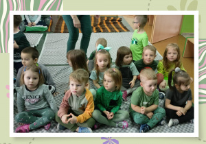 Zdjęcie grupowe dzieci siedzących i oglądających przedstawienie „Wiosna w wiosce Smerfów”.