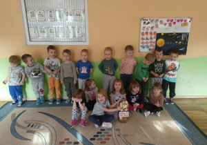 Grupowe zdjęcie dzieci z grupy Biedronki. Wspólnie oglądaliśmy monety, po czym wrzuciliśmy je do przeznaczonego pojemnika.
