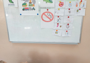Dzieci z grupy Tropiciele oglądają plakaty i znaki zakazujące palenie obok wiszą znaczki z zakazem palenia, które wykonały dzieci.