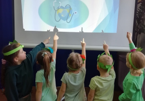 Dzieci wskazują na napis Światowy Dzień Zdrowia wyświetlony na ekranie.