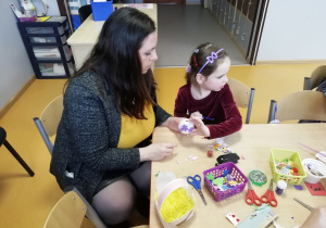 Mama z córką dekorują styropianowe jajko.