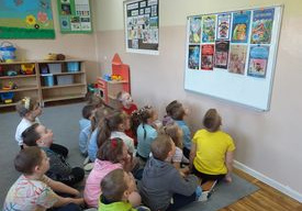 Dzieci słuchają wiadomości o różnych bajkach. Nauczyciel prezentuje okładki najpopularniejszych bajek.