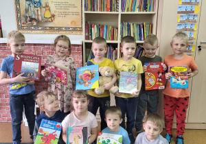 Dzieci z grupy Motylki trzymają w rękach książki z przedszkolnej biblioteczki, które wypożyczyły do domu.